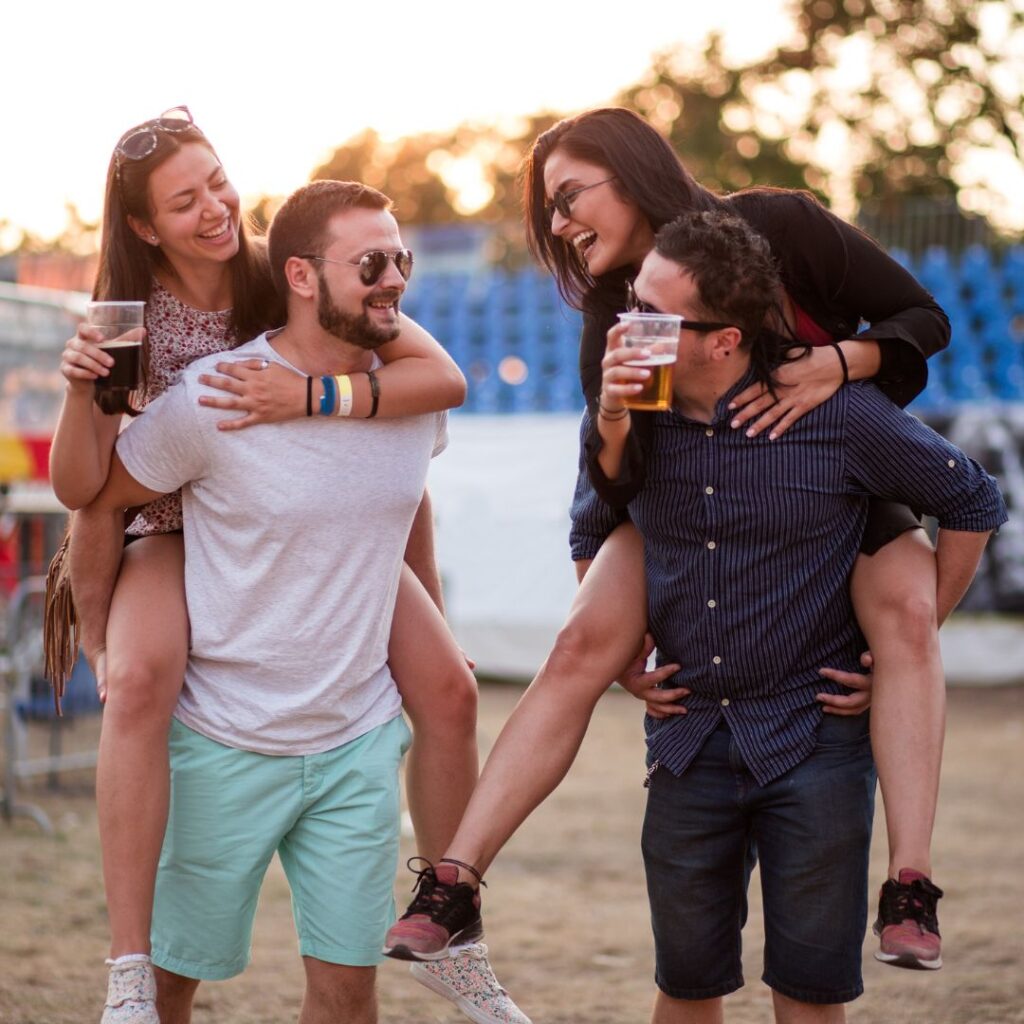 Dubbeldejt på en musikfestival där kvinnorna rider på männens ryggar.
