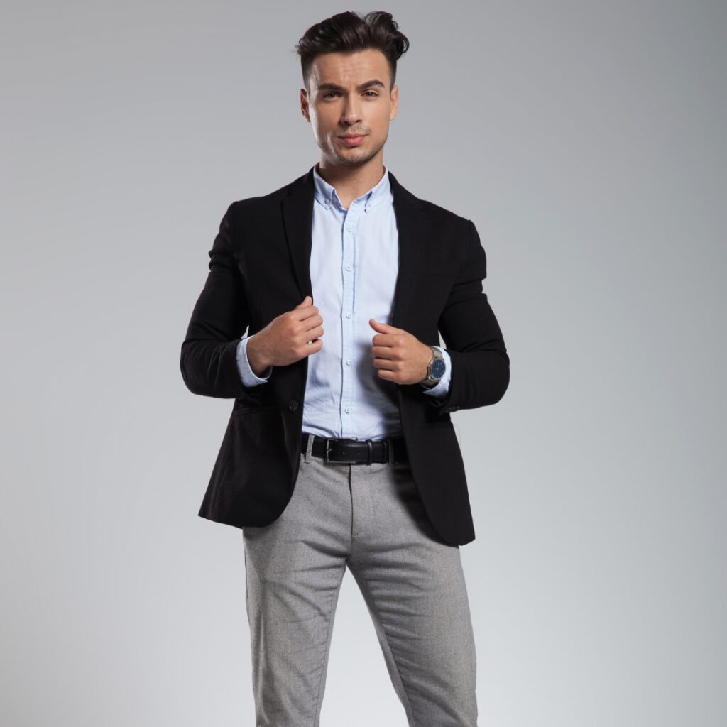 Man poserar mot kameran med smart casual klädsel i stilren stil